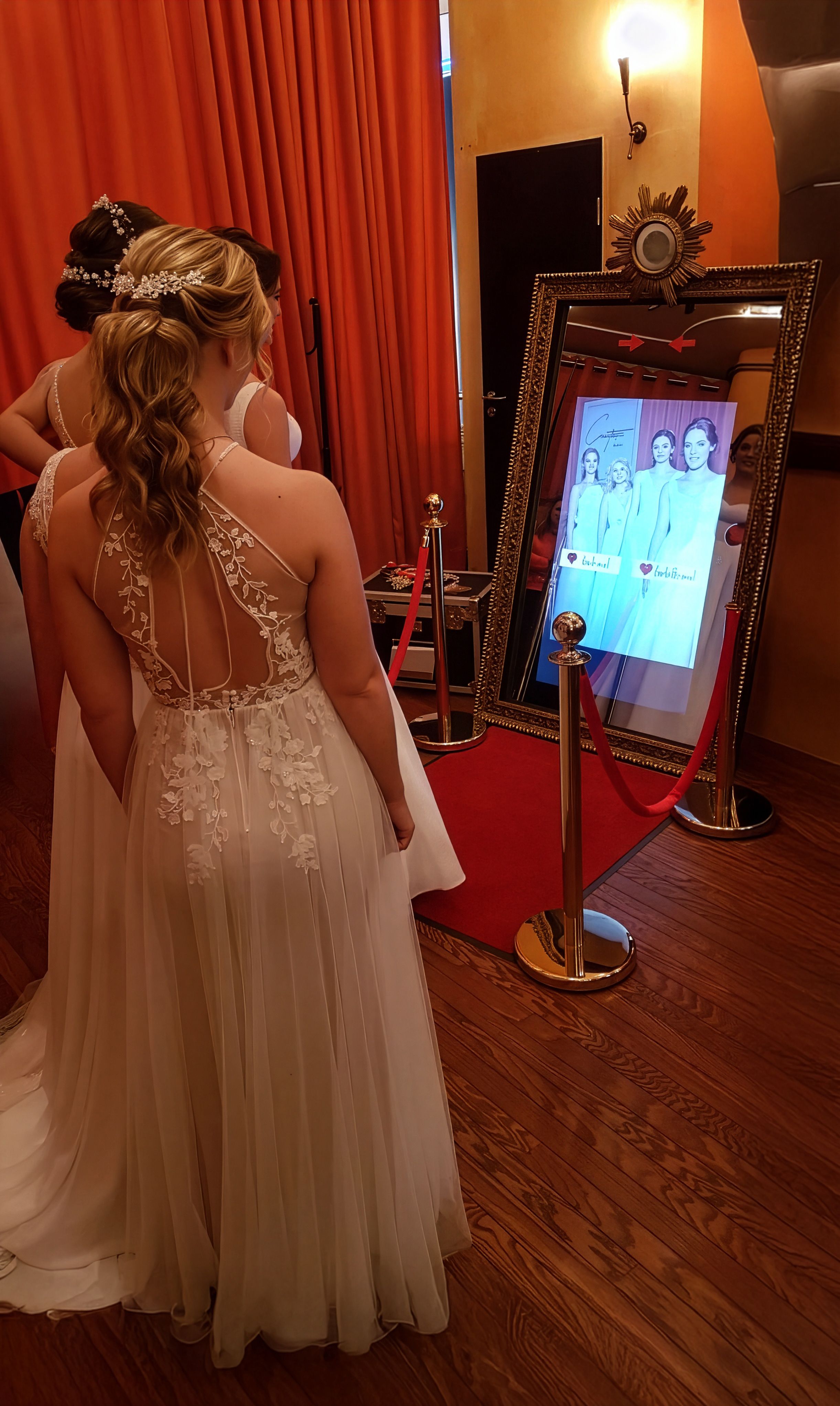 Vier lachende Frauen am Flash-U Fotospiegel bei einer Hochzeit